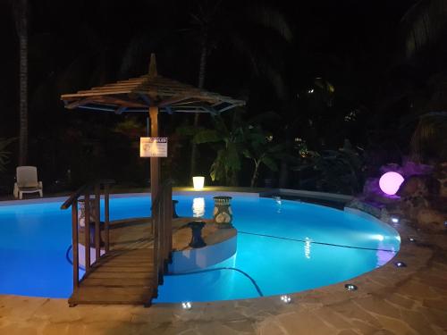 a swimming pool at night with a table and an umbrella at Villa Tourelle of Paradise with bigPrivate Pool in Rivière Noire