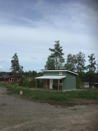 una pequeña casa verde en medio de un campo en Larstorpsvägen 12 en Trollhättan