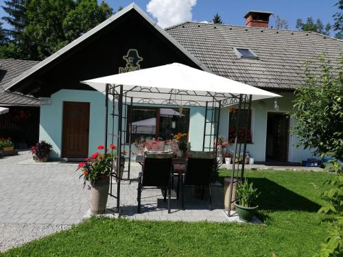 a table with an umbrella in front of a house at PR`Cajhn in Radovljica