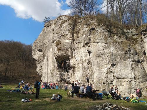 a group of people sitting around a rock formation at Schronisko Młodzieżowe Małgosia in Łazy