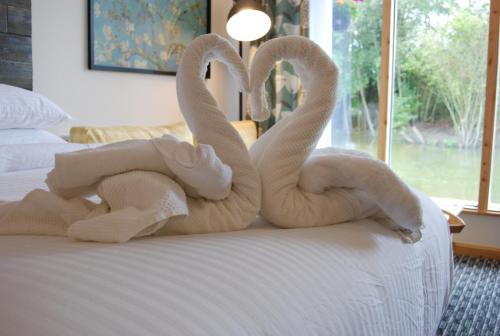 two towel swans sitting on top of a bed at TheWaterfrontLodges in Coventry