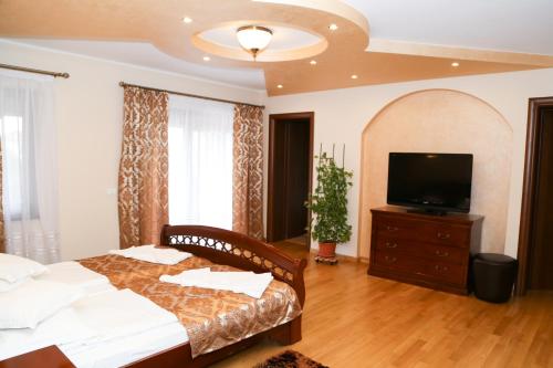 a bedroom with a bed and a flat screen tv at Oli House in Alba Iulia
