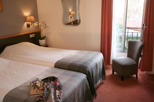 Habitación de hotel con cama, silla y ventana en Denfert-Montparnasse en París