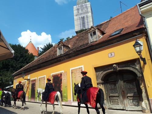 a group of people riding horses down a street at Apartment History in Zagreb