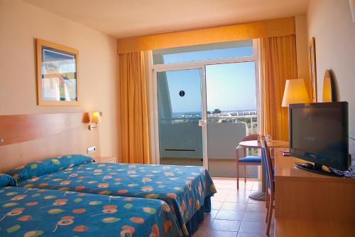 a hotel room with a bed and a tv and a window at Hotel Servigroup Marina Mar in Mojácar