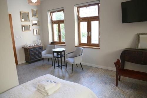 a bedroom with a bed and a table and chairs at Aparthotel Zakątna B&B in Tarnów