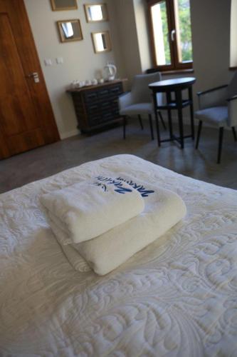 a white towel sitting on top of a bed at Aparthotel Zakątna B&B in Tarnów
