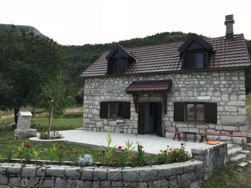 a stone house with a bench in front of it at Lovcen Holiday Home in Cetinje