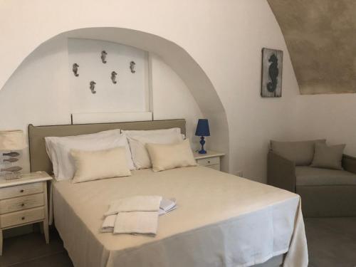 a bedroom with a large bed and a chair at Il Giardino Della Regina in Gallipoli