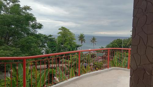 a balcony with a red railing and a view of the ocean at Villa Marquez in Camotes Islands