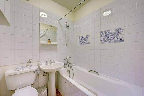 a bathroom with a sink and a toilet and a bath tub at Hampstead Stylish Apartment Brilliant Location in London