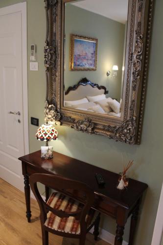 a mirror on a wall above a table with a bed at B&B Fine Venice in Marghera