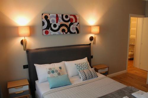 a bedroom with a bed with pillows and a painting on the wall at B&B Fine Venice in Marghera