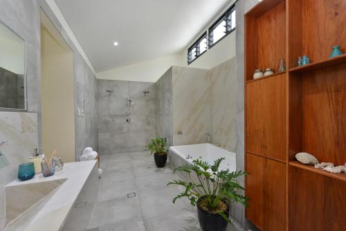 W łazience znajduje się wanna, umywalka i prysznic. w obiekcie The Port Douglas Beach House w mieście Port Douglas