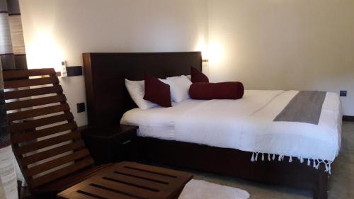 a bedroom with a bed with white sheets and red pillows at Amazing Villa in Matara