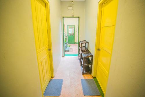 a hallway with an open door and a hallway with blue mats at Barn1920s Hostel in Vientiane