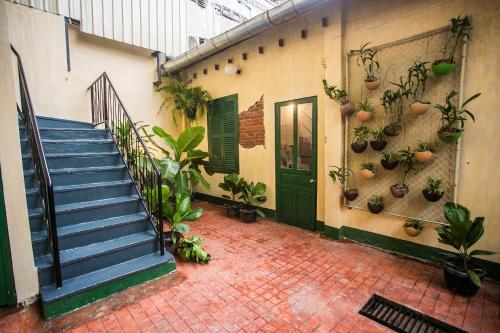 a building with a staircase and potted plants on the wall at Barn1920s Hostel in Vientiane