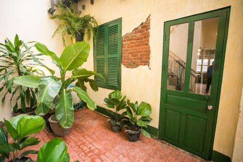 a green door with plants in front of a building at Barn1920s Hostel in Vientiane