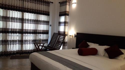 a bedroom with a bed and a window with curtains at Amazing Villa in Matara