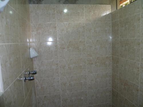 a bathroom with a shower with beige tile at HOSPEDAJE CAMPOS ELÌSEOS in Oxapampa