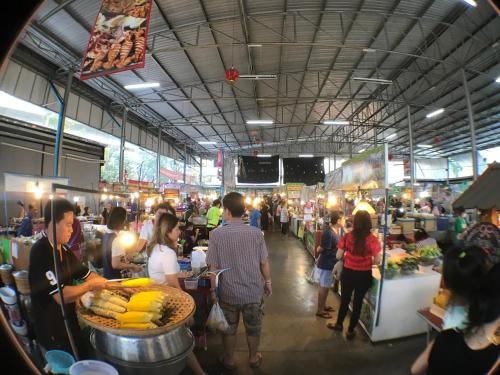 a group of people standing in a market with food at 28 Place in Bangkok