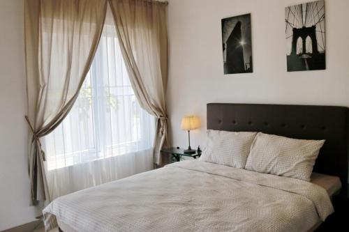 a bedroom with a large bed and a window at NZHome Residence in Karawang