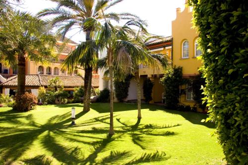 un patio con palmeras frente a un edificio en Apartamentos Soho Boutique Vistahermosa, en El Puerto de Santa María
