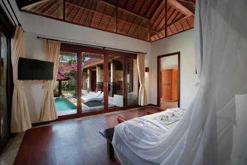 um quarto com uma cama e vista para uma piscina em Bali Prime Villas em Seminyak