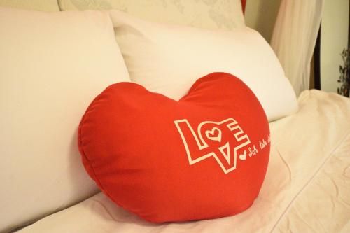 a red heart shaped pillow sitting on a bed at 世外桃園民宿 in Taitung City