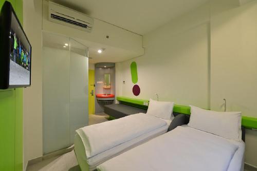 Camera ospedaliera con 2 letti e TV a schermo piatto di POP! Hotel Timoho Yogyakarta a Yogyakarta