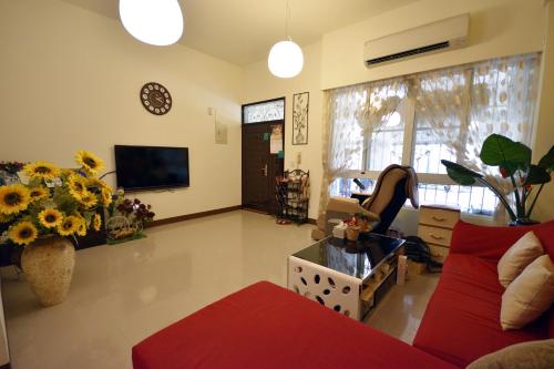 a living room with a red couch and a tv at 世外桃園民宿 in Taitung City