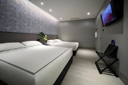a hotel room with a couch and a television at Hotel Classic by Venue - SG Clean in Singapore