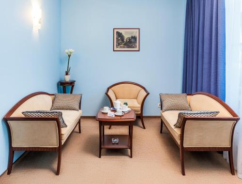 a room with three chairs and a table with cups on it at Alexandrovsky Garden in Nizhny Novgorod