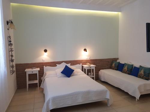 a hotel room with two beds and two tables at Ippokampos in Hydra