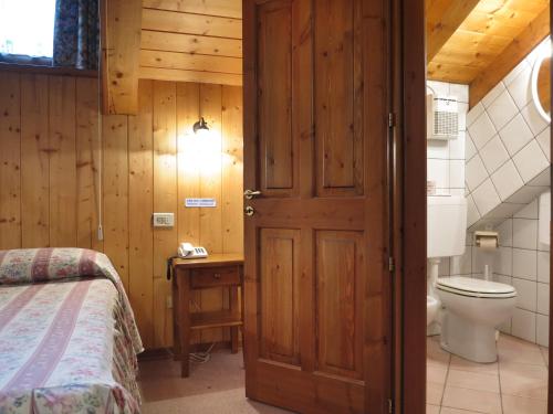 コー​​ニュにあるHotel Locanda Grausonのバスルーム(ベッド1台、トイレ、ドア付)