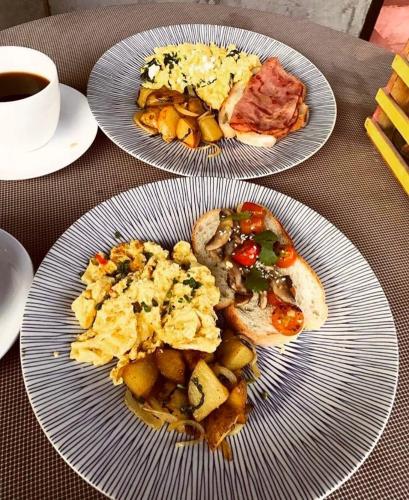 two plates of breakfast food on a table with coffee at Bali Ayu Hotel & Villas in Seminyak