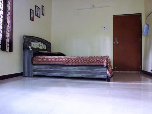 a bed sitting in a room with a door at Ashish Baug Cottage in Alibaug