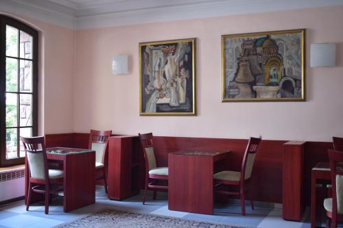 a restaurant with tables and chairs and paintings on the wall at Hotel Jeravna in Bankya