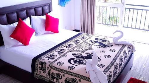 a bedroom with a bed with two swans on it at Jaye's Homestay in Kandy