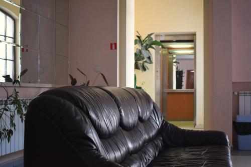 a black leather couch sitting in a living room at Hotel Jeravna in Bankya