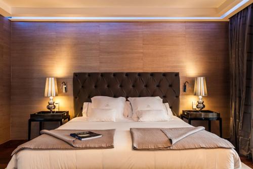 Gran Hotel Nagari Boutique & Spa في فيغو: غرفة نوم مع سرير كبير مع طاولتين نهايتين