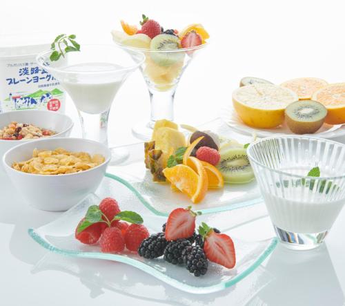 a table with plates of fruit and wine glasses at HOTEL VISCHIO AMAGASAKI by GRANVIA in Amagasaki