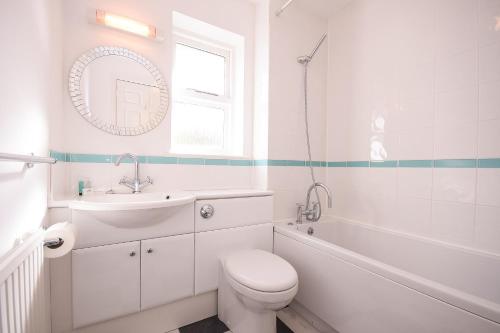 a white bathroom with a toilet and a sink at Town or Country - Captains Place in Southampton