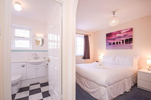 a bedroom with a white bed and a bathroom at Town or Country - Captains Place in Southampton