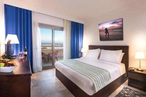 a bedroom with a bed and a view of the ocean at Aura Resort Sidi Abd El Rahman El Alamein in Sīdī ‘Abd ar Raḩmān