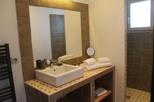 a bathroom with a sink and a mirror at Hotel & Restaurant Les Bergeries d'Alata in Alata