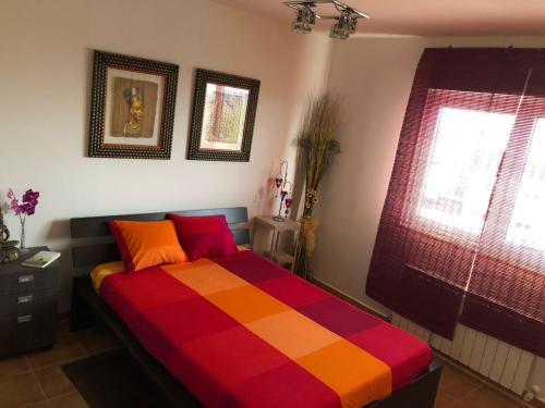 a bedroom with a colorful bed with two windows at Serengueti in Los Ángeles de San Rafael