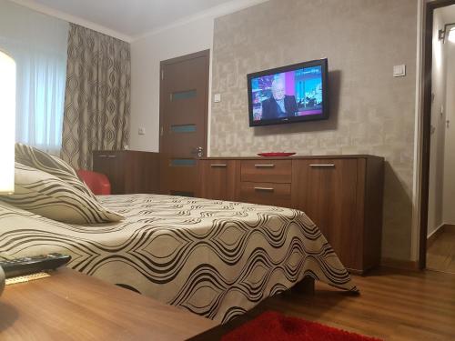 a bedroom with a bed and a flat screen tv at Casa Mirage in Craiova