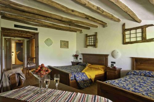 a bedroom with two beds and a table with wine glasses at La Brace in Forcola