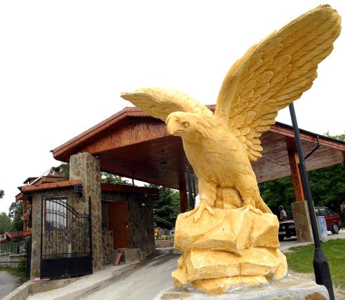 uma estátua de uma águia em frente a um edifício em Хотел Галина Палас em Srem